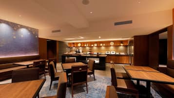 A restaurant with a bar area, wooden furniture, and a patterned wall.