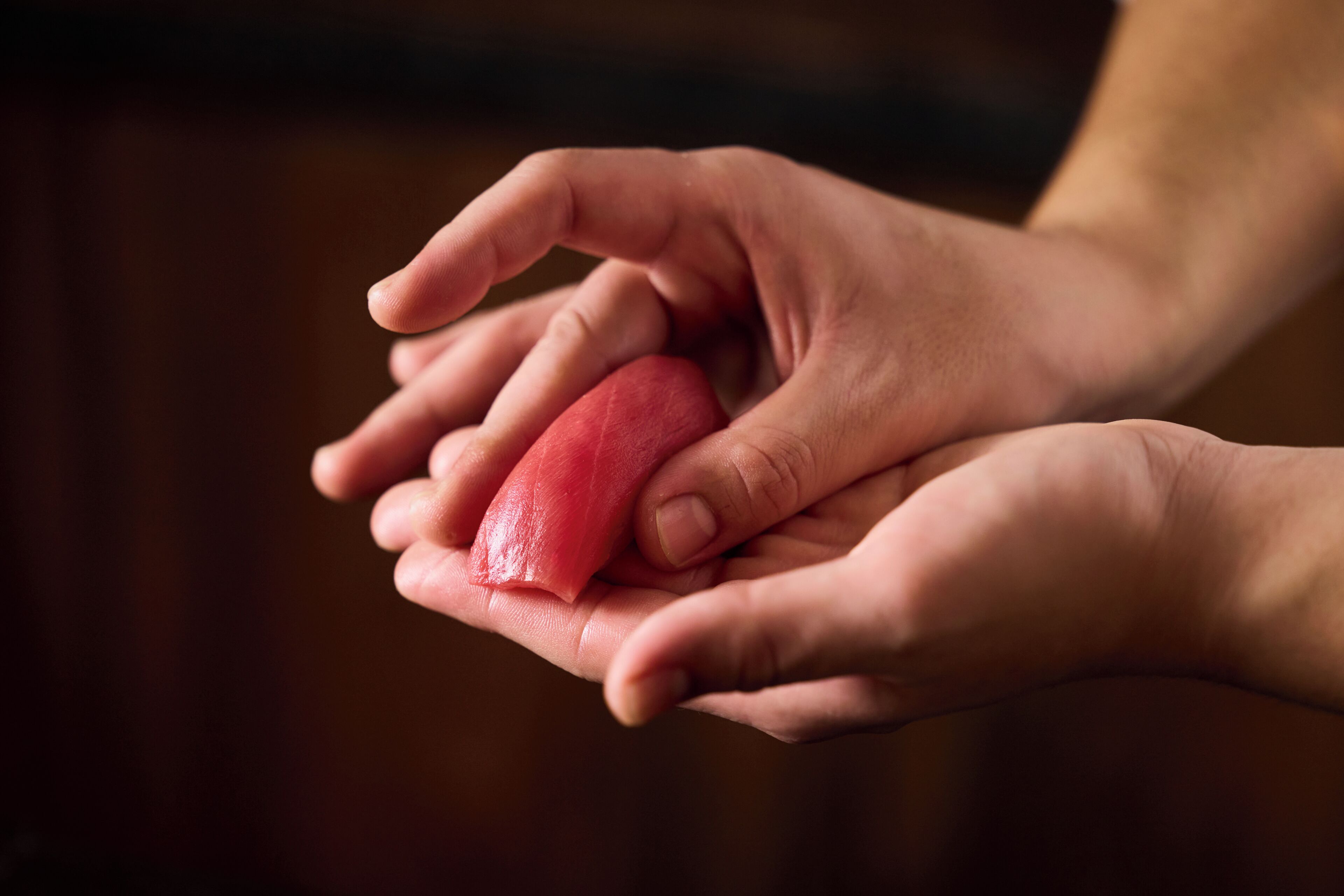 A pair of hands holding a red object.