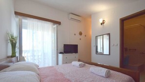 Ein Hotelzimmer mit einem Bett, einem Fernseher, einem Spiegel und einer Tür.