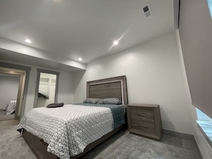 Un dormitorio con cama, mesita de noche y armario.