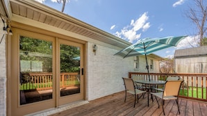 A covered patio with a table and chairs, a sliding glass door, and a wooden deck. - Your Kentucky Home (Georgetown)