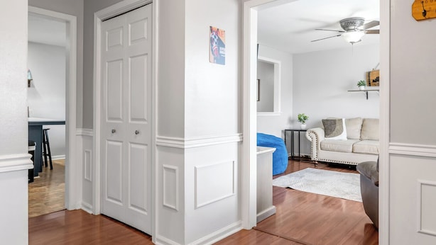 A hallway with wooden flooring, white walls, and a ceiling light fixture. - Your Kentucky Home (Georgetown)