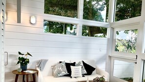 Une pièce chaleureuse avec un canapé blanc, une petite table en bois et une plante en pot.