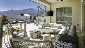 A spacious outdoor living area with wicker furniture, a flat-screen TV, and a view of mountains. - Good Life La Quinta!  PGA West! Mist/Pool/Spa/Putt (La Quinta)
