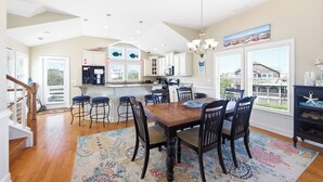 Una cocina amplia con comedor, ventanas grandes y vista a barcos.