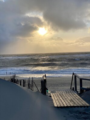 Une plage avec une jetée en bois et une zone de sable.