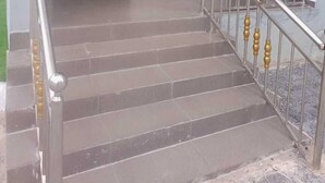 Eine Treppe mit Metallgeländer und einer Tür am oberen Ende.