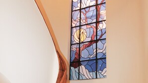 A staircase with a wooden handrail and a stained glass window depicting a tree. - Modern apartment with roof terrace in Athens (Athens)