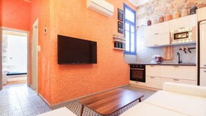 A compact kitchen with a flat-screen TV, a microwave, and a coffee maker. - Modern apartment with roof terrace in Athens (Athens)