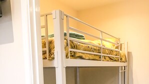 Ein Etagenbett mit einem blumigen Bettbezug und einem grünen Kopfkissen.
