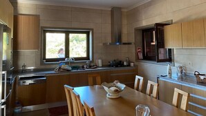 Eine moderne Küche mit Holzschränken, einer zentralen Kochinsel und einem Fenster für natürliches Licht.