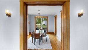 A dining area with a wooden table, chairs, and a chandelier.