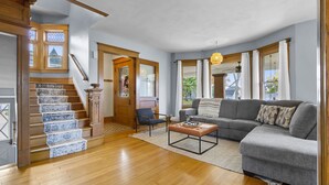 A spacious living room with a staircase, a gray sofa, and a coffee table.