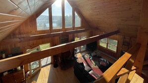 Ein geräumiges Loft mit hohen Decken, großen Fenstern und Blick ins Freie.
