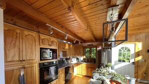 Eine geräumige Küche mit Holzausstattung, Edelstahlgeräten und einem großen Fenster für natürliches Licht.