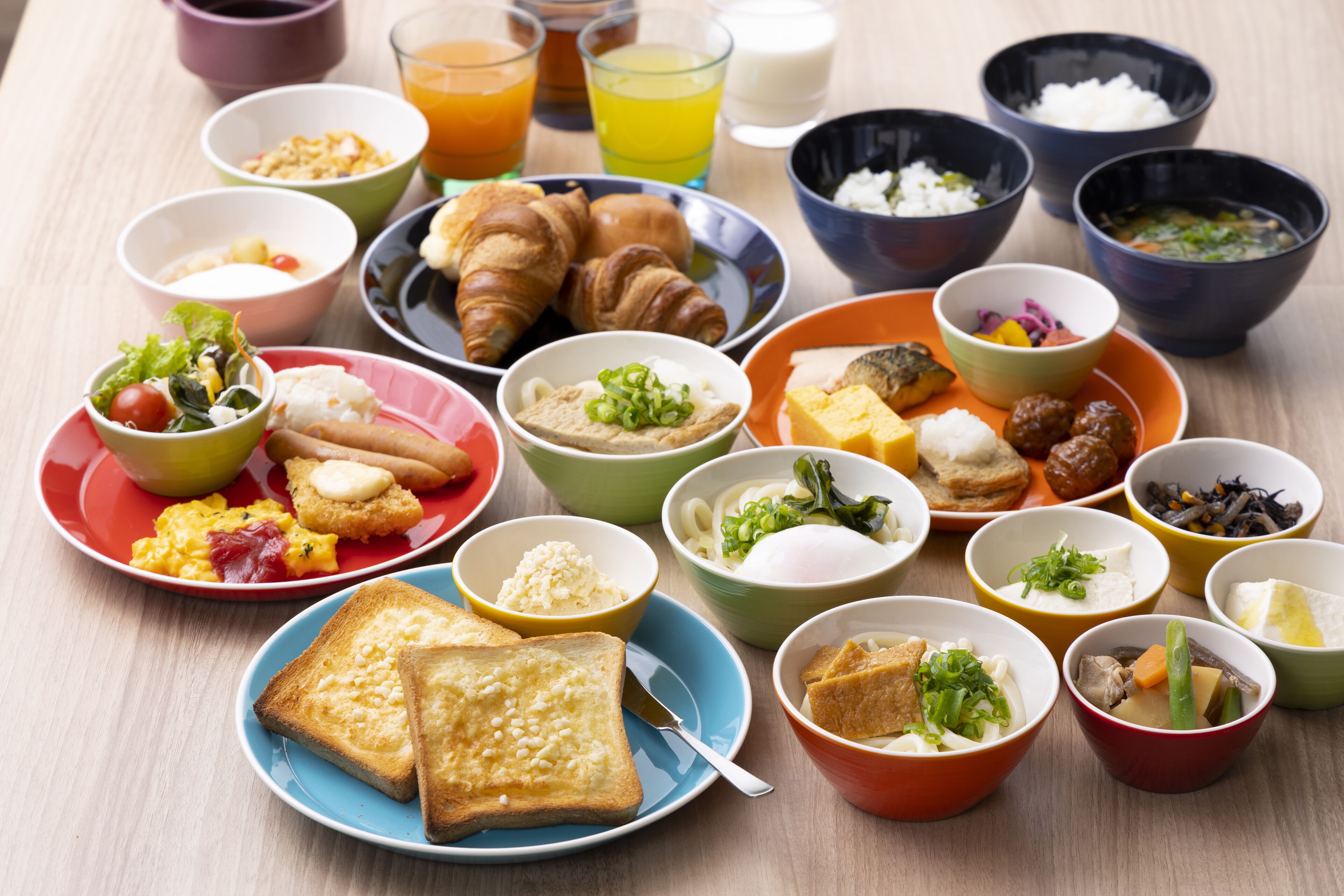 A variety of breakfast dishes including croissants, toast, and bowls of soup and salad.