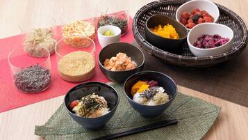 Diversos pratos japoneses dispostos sobre uma mesa, com hashis e tigelas.