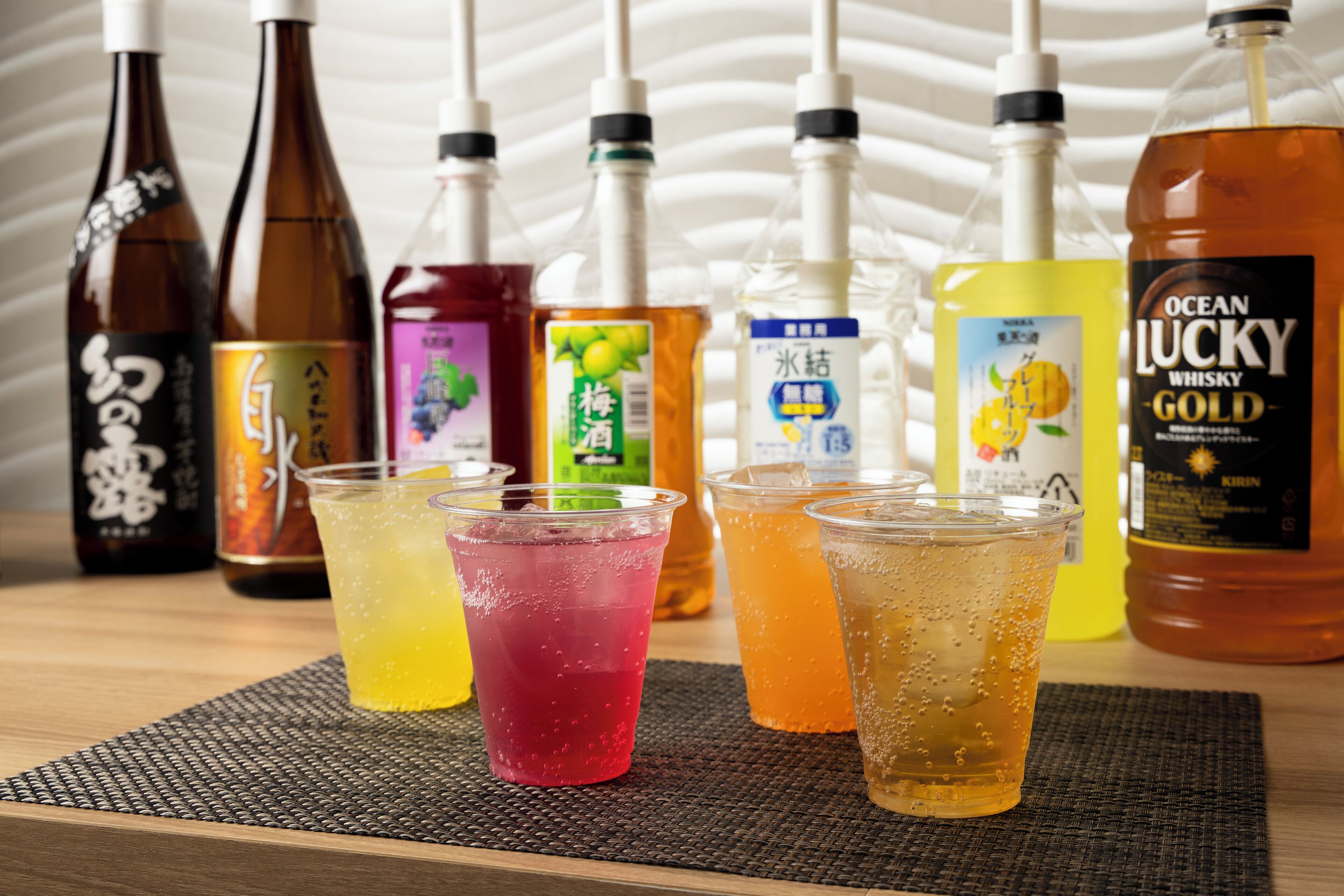 Uma mesa com várias garrafas e copos de bebidas.