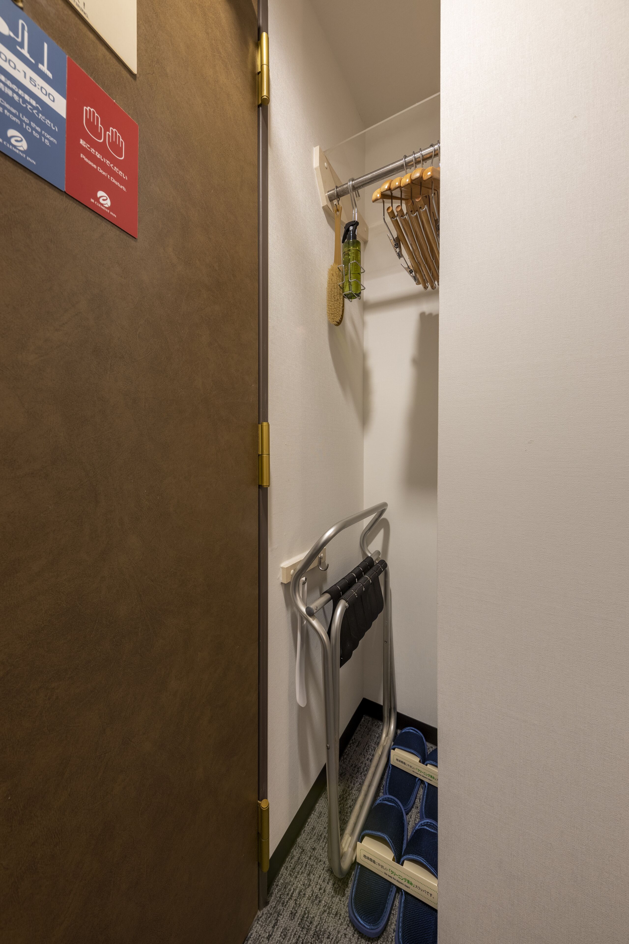 A hotel bathroom with a towel rack, a shower curtain, and a sign indicating amenities.