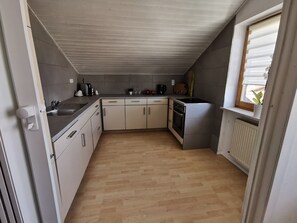 Eine kleine Küche mit Spüle, Herd und Schränken.