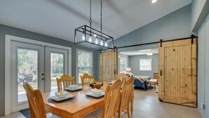 A dining area with a wooden table, chairs, and a hanging light fixture. - Spacious Arcadia Escape Near Public Boat Ramp (Arcadia)