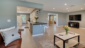 A spacious living area with a kitchen island, a dining area, and a TV mounted on the wall. - Spacious Arcadia Escape Near Public Boat Ramp (Arcadia)