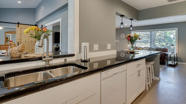 A modern kitchen with a double sink, white cabinets, and a large window providing natural light. - Spacious Arcadia Escape Near Public Boat Ramp (Arcadia)