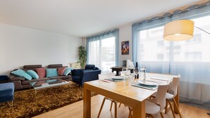 Ein modernes Wohnzimmer mit einer Couch, einem Couchtisch und einem Esstisch.