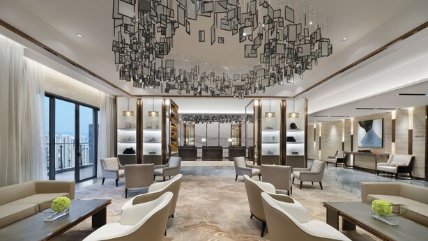 A modern hotel lobby with a central seating area, a reception desk, and a large window offering a city view. - Oakwood Residence Foshan (Foshan)