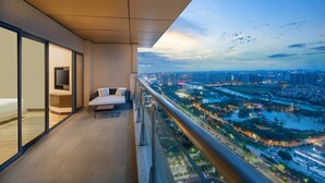 A balcony with a city view, a sofa, and a TV. - Oakwood Residence Foshan (Foshan)