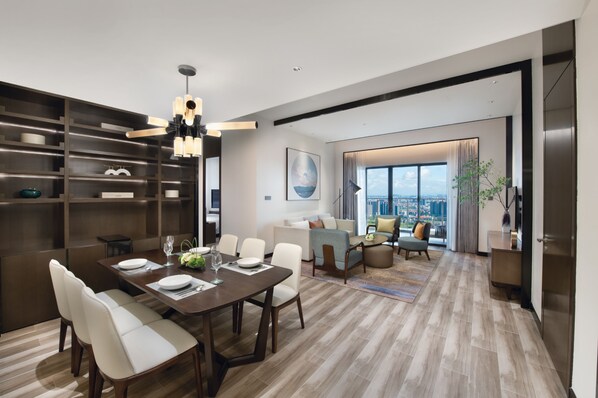 A modern living room with a dining area, large windows, and a city view. - Oakwood Residence Foshan (Foshan)