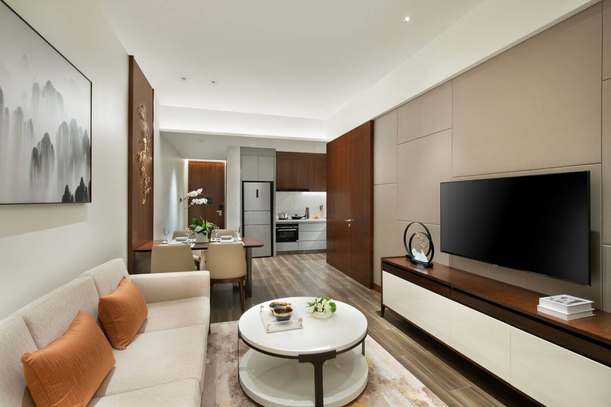 A modern living room with a sofa, coffee table, and a flat-screen TV.