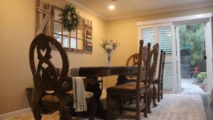 A dining area with a wooden table and chairs, a ceiling fan, and a view of the outdoors through a sliding glass door. - Casa Esperanza. Peaceful Get-away W/Hot Tub. (Salinas)