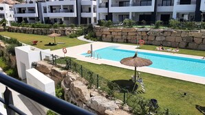 A swimming pool with a lifebuoy, lounge chairs, and a thatched umbrella. - Atico apartment with views of the Casares golf course, 3,00 metres from Finca Cortesin (Casares Costa Golf)