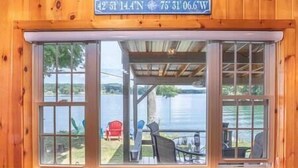 A wooden cabin with a large window overlooking a lake. - Lakefront, 5 min to Colgate, Sleeps 6, Kayaks (Hamilton)