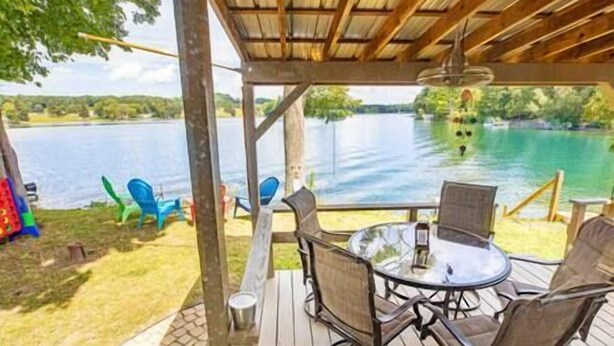 An outdoor deck with a table and chairs, overlooking a lake. - Lakefront, 5 min to Colgate, Sleeps 6, Kayaks (Hamilton)