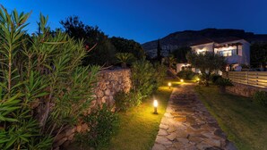 A stone pathway leading to a house with a mountain backdrop. - Villa Oceanis (Lindos)
