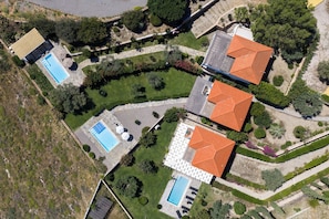 Vista aérea de una zona residencial con varias casas, cada una con un estilo de techo diferente y rodeadas de jardines cuidados.