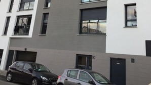 A multi-story building with a modern architectural design, featuring large windows and balconies. - Chambres d'hôtes de Luxe Ma SuK (Saint-Denis)