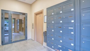 A hallway with a glass door, a wooden door, and a row of blue filing cabinets. - Chambres d'hôtes de Luxe Ma SuK (Saint-Denis)