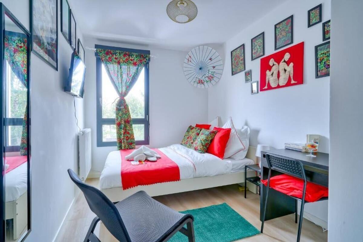 Une chambre à coucher avec un lit, un bureau, une chaise et une fenêtre avec des rideaux.