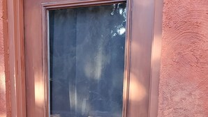 A brown door with a glass panel and a doorknob.