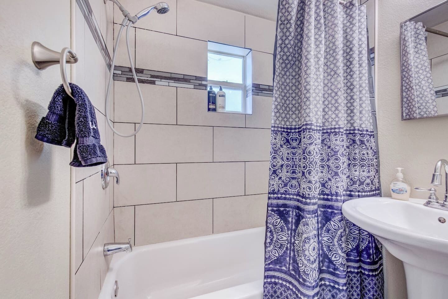 A bathroom with a bathtub, a shower, and a sink.