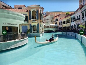 A gondola ride in a water canal with buildings on either side. - Pandora’s Nest Pasig 2BR Family & Pet-Friendly Haven for Extended Stays (Pasig)