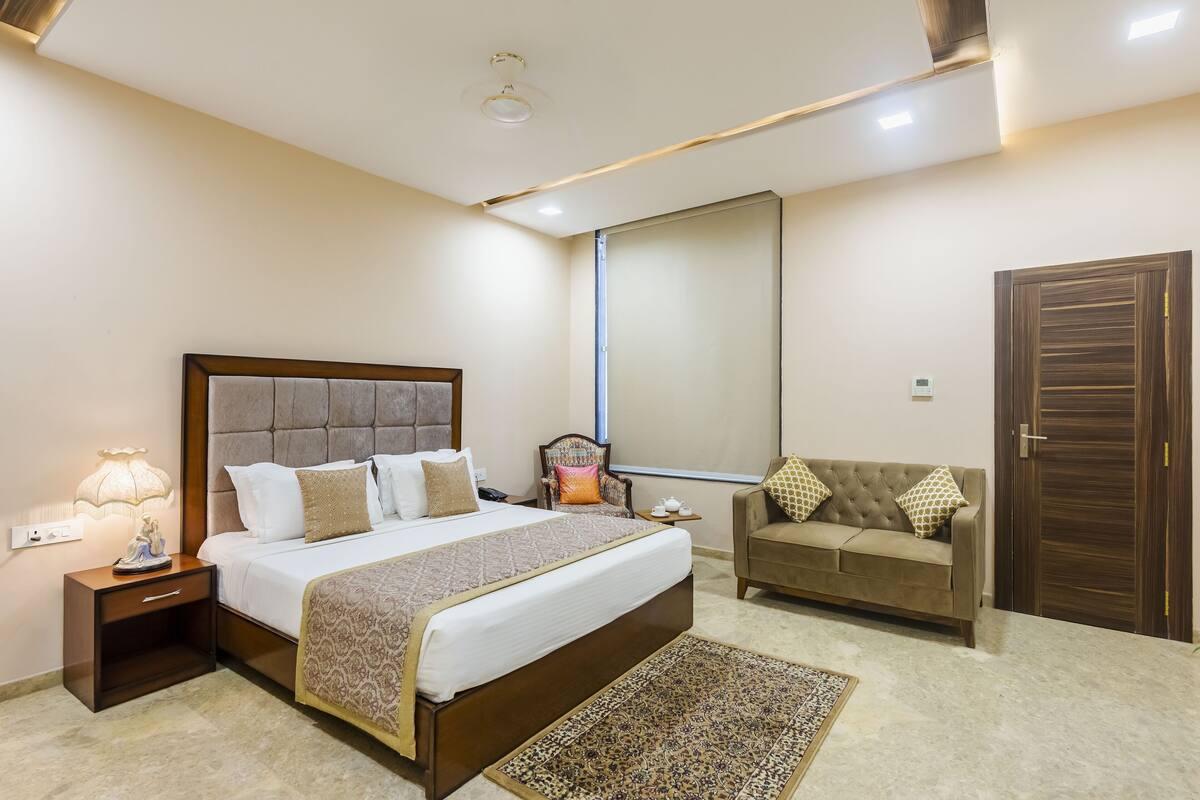 Une chambre à coucher comprenant un lit, une table de chevet, une commode, une chaise et une armoire.