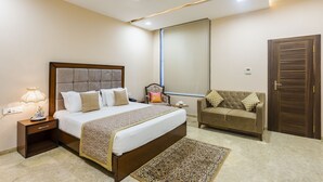Ein Schlafzimmer mit einem großen Bett, Nachttisch, Stuhl und einem Kleiderschrank.