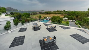 Eine Dachterrasse mit Sitzgelegenheiten im Freien, einem Pool und Blick auf die umliegende Landschaft.