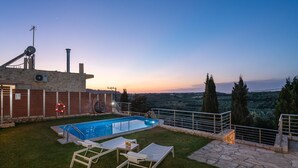 A swimming pool with lounge chairs and a stone pathway, surrounded by a stone wall and a view of the countryside. - Stefania Villa Ena in Roumeli (Mylopotamos)
