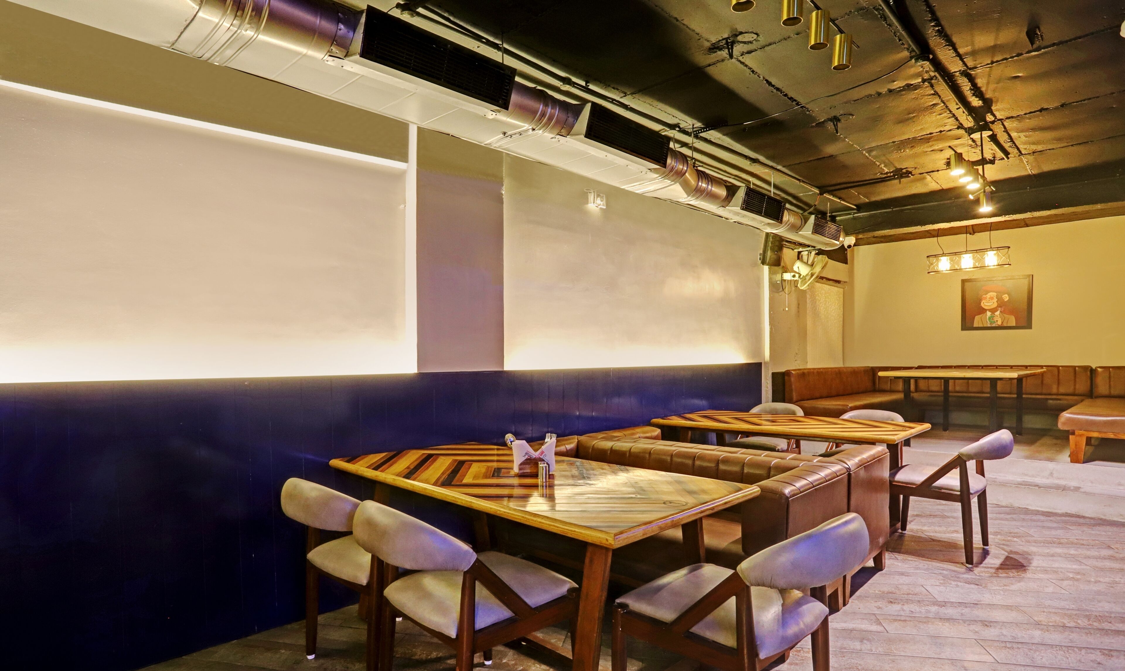 A restaurant with booth seating, a stage, and a projector screen.