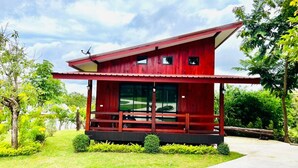 A red wooden house with a large window and a porch. - Pruksa View Homestay (Nam Nao)